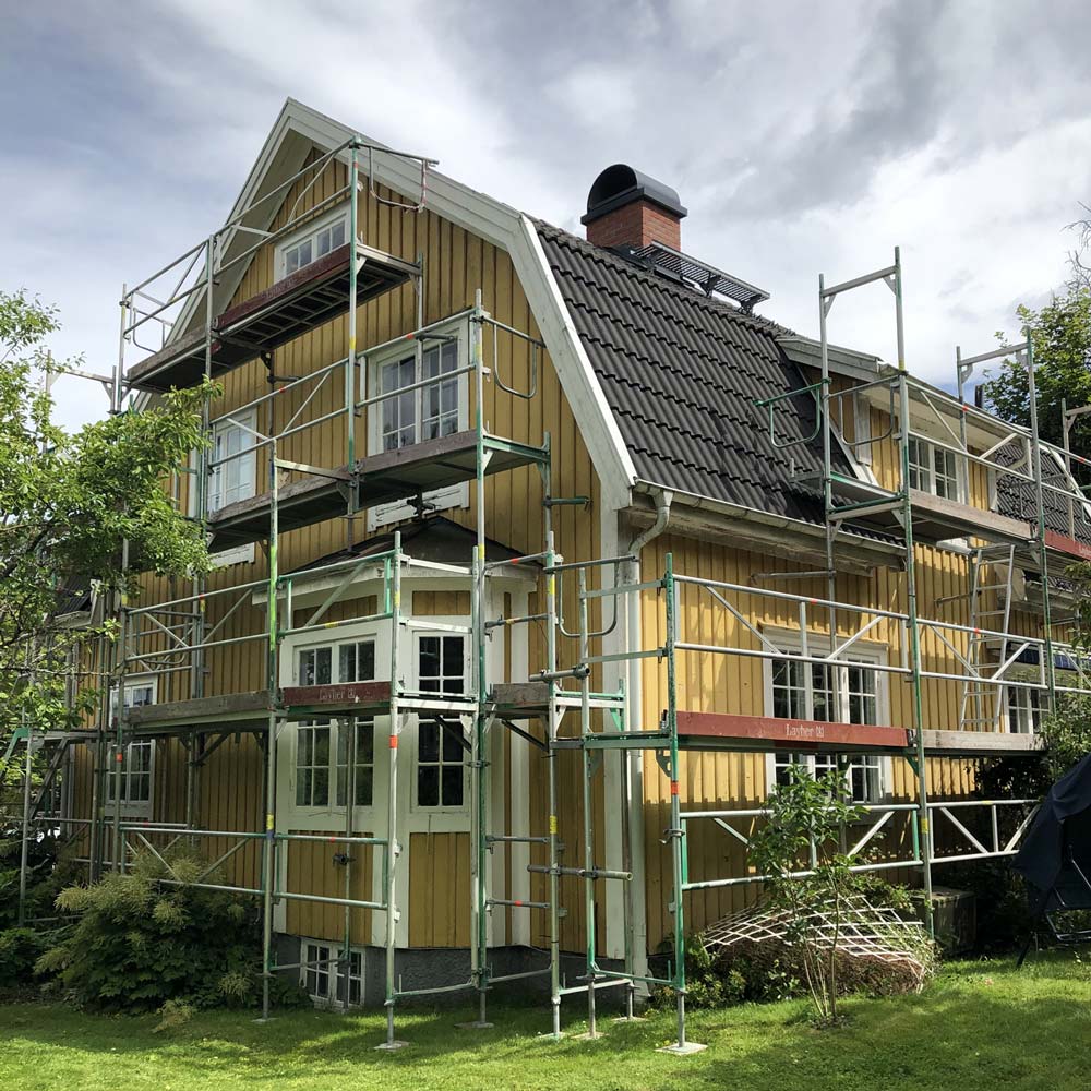 Gult hus där fasadmålning ska utföras